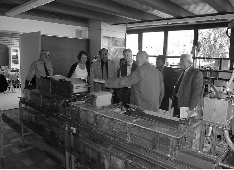 Der madagassische Botschafter vor einer Miniatur-Papiermaschine.